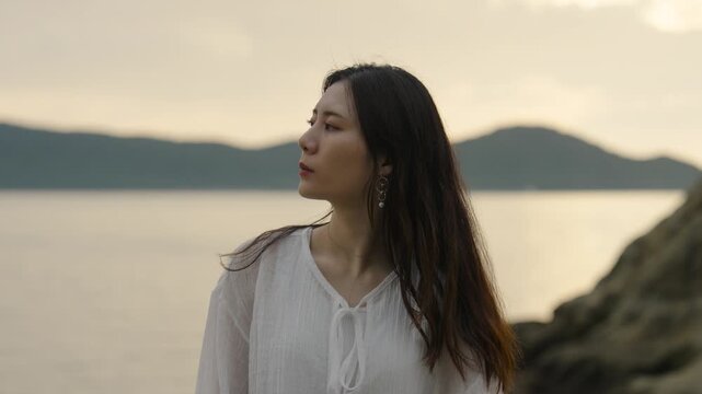 夕暮れの海にいる女性