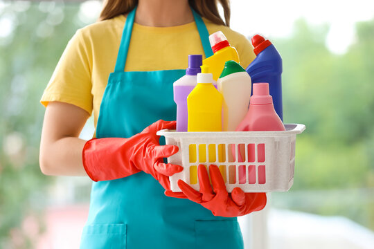 Female janitor with cleaning supplies near window, closeup