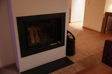 Obraz premium Modern fireplace with glass door and wood logs inside, cozy home interior design element, warmth and comfort
