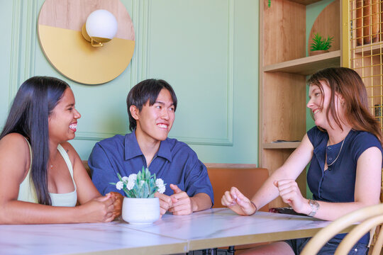 Young Woman Smiling While Chatting with Friend in Modern Cafe
