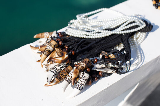 Beach souvenir vendor offering handmade jewelry and shark tooth necklaces in tropical Philippines