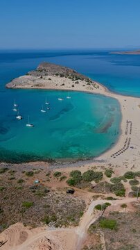Discover the stunning beauty of Simos Beach, where golden sands meet turquoise waters. Experience relaxed vibes, sailboats gently rocking, Elafonisos Island, Greece