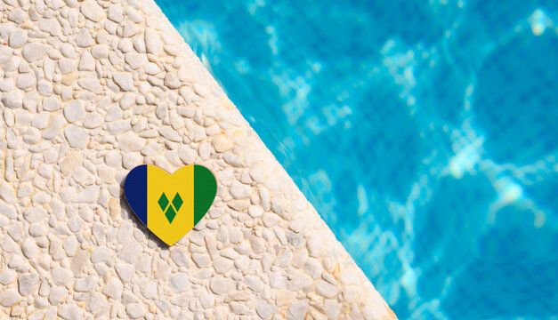 Saint Vincent and the Grenadines flag in the shape of a heart near the pool in the hotel. Holiday concept in hotels