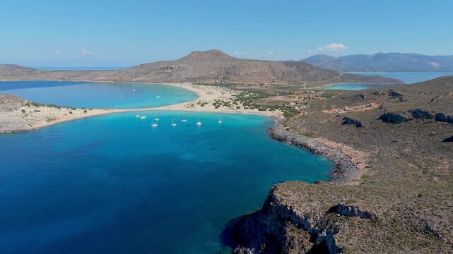 Experience the serene allure of Simos Beach in Elafonisos, Greece. The crystal-clear waters meet golden sands under a clear sky, creating an ideal destination for relaxation and adventure.