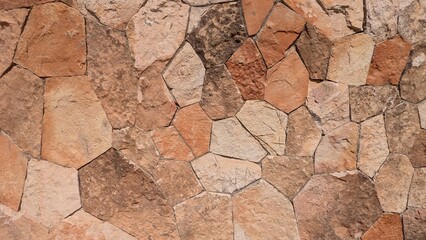 Fototapeta premium A close-up view of a rustic stone wall with irregularly shaped stones and natural textures.