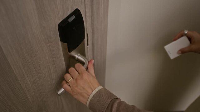 Cropped shot of woman tapping electronic keycard on smart lock and opening hotel room door, suitable for hotel promotion, travel agency campaigns, and modern security system ads