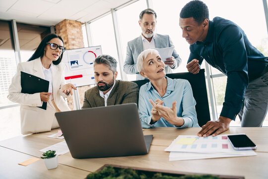 Team engaging in a collaborative discussion at a corporate office workspace, showcasing teamwork and professional commitment.