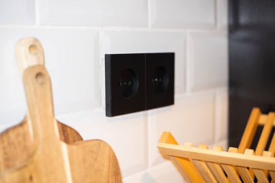 Black Sockets in the wall, wires in the socket on the kitchen wall, overloaded wall sockets, home fire safety concept. High quality