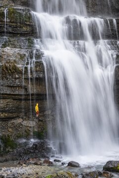 Adventure, Little hiker under large Cascata di Mezzo waterfall, long exposure, Vallesinella, Brenta, Trentino, Italy