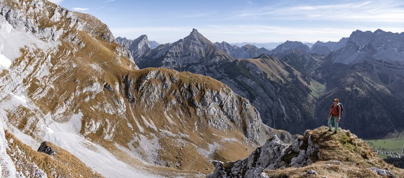 Female hiker standing on a rock and looking into the valley, hiking to Gamsjoch, down the Ahornboden valley, eastern Karwendel, Tyrol, Austria