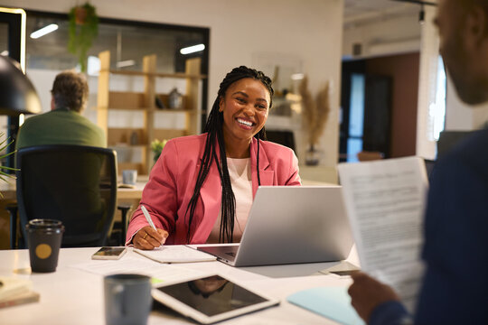 Cheerful african american businesswoman looking at her colleague and smiling