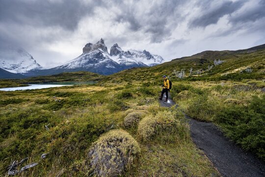 Hikers on the way to the Mirador de los Cuernos, Cuernos del Paine mountain range, dramatic sky, Torres del Paine National Park, Chile