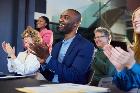 Group of happy multiethnic business people clapping hands during conference