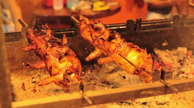 Traditional Filipino lechon manok roasting over charcoal, authentic street food