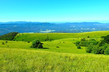 Green grassland at Vremščica hill with Brkini in the distance in Primorska, Slovenia © kato08