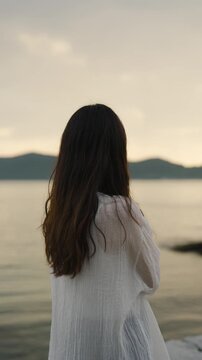 夕暮れの海にいる女性