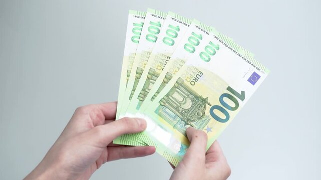Female hands counting stack of euro banknotes isolated on white background. Financial planning, savings, cash payment, investment and money management concept.