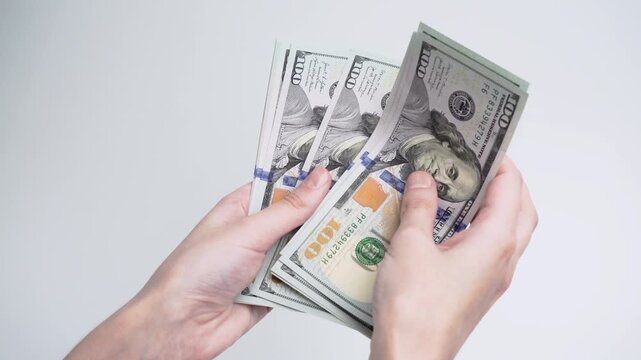 Female hands counting stack of dollar banknotes isolated on white background. Cash payment, savings, financial planning, investment and money management concept.