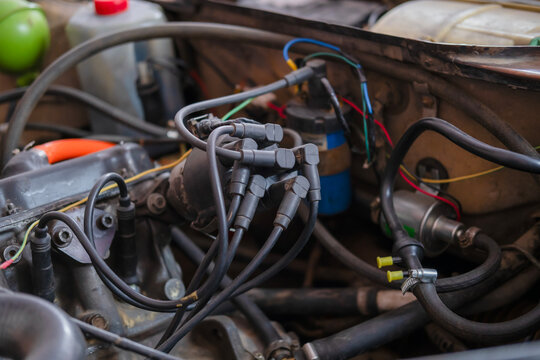 Close-up of an old car engine bay with distributor and spark plug wires