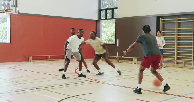 Receiving coach signal, african american man executing crossover dribble past defender in the arena