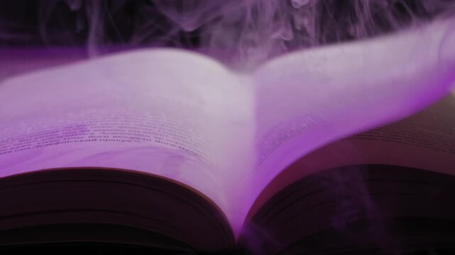 An open spellbook shrouded in mystical purple smoke has its pages turned by an unseen force against a dark background. Concept of forbidden knowledge, ancient magic, and mysterious storytelling
