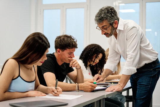 Teacher helping students during a classroom lesson