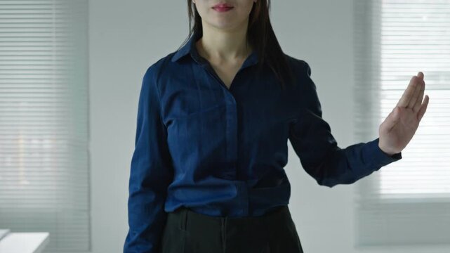Business woman swiping a virtual interface from right to left with open palm gesture, suitable for digital navigation, technology mockup and UI concepts