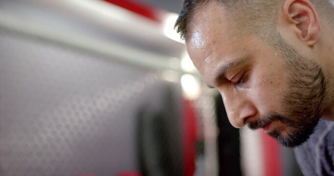 Finishing rep, mid-adult indian man bending over gym bench, breathing before next set