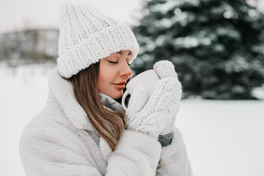 Caucasian Ukrainian Woman Warming Hands with Hot Coffee in Snowy Winter Nature