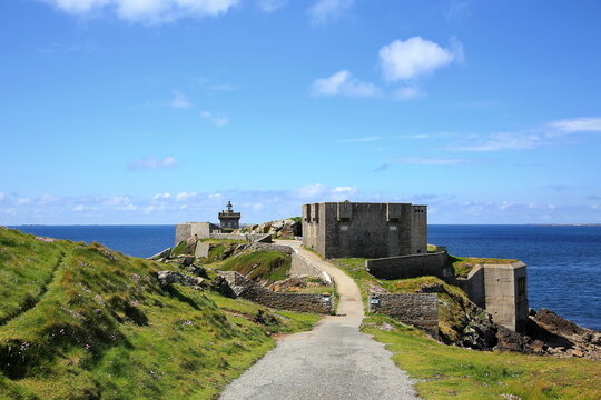 Kermorvan-Leuchtturm an der felsigen K&uuml;ste der Bretagne. Das historische Bauwerk steht auf einer Landzunge umgeben vom blauen Atlantischen Ozean unter strahlendem Himmel.