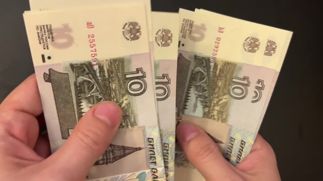Counting rouble banknotes. Female hands count 10 russian roubles cash. Frugality, family budget, and savings concept