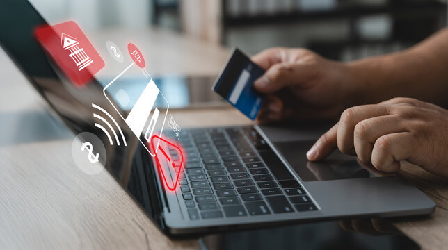 Person holding a credit card while using a laptop with security alert interface, illustrating online payment fraud detection, transaction monitoring, cybersecurity protection and digital banking risk 
