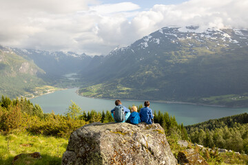 Fototapeta premium People, adult with kids and pet dog, hiking mount Hoven, enjoying the splendid view over Nordfjord from Loen skylift