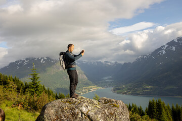 Obraz premium People, adult with kids and pet dog, hiking mount Hoven, enjoying the splendid view over Nordfjord from Loen skylift