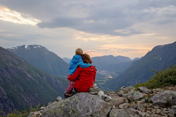Fototapeta premium Family with children and dog, hiking in Litlefjellet on sunset, enjoying amazing view from the top of hiking trail