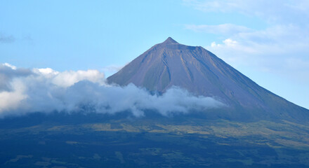 Fototapeta premium View of the highest mountain in Portugal, Ponta do Pico, clouds covering the cone, on Pico Island, Azores