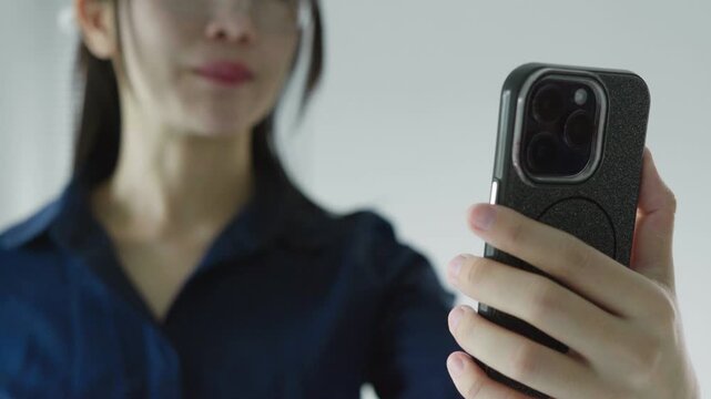 Business woman using a smartphone for a video call, ideal for remote communication, online meetings, virtual collaboration, mobile technology and work concepts
