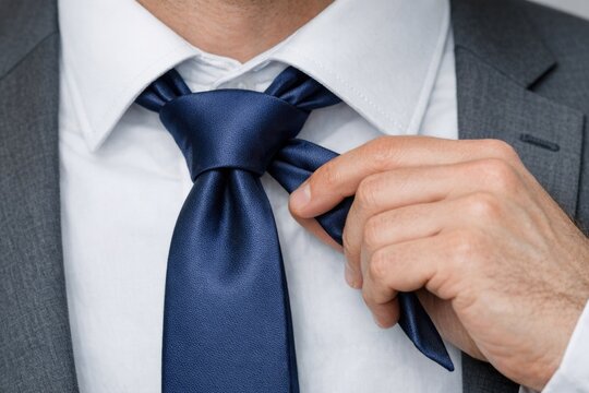 A close-up shot of a person wearing a formal suit and tie, suitable for business or professional use
