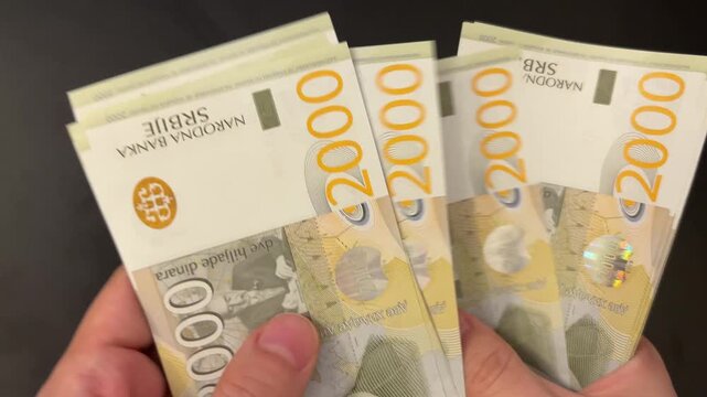Counting Serbian dinar banknotes. Female hands counting 2000 RSD bills. Family budget, savings and investment concept