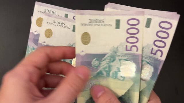 Counting Serbian dinar banknotes. Female hands counting 5000 RSD bills. Savings, investment and personal finance concept