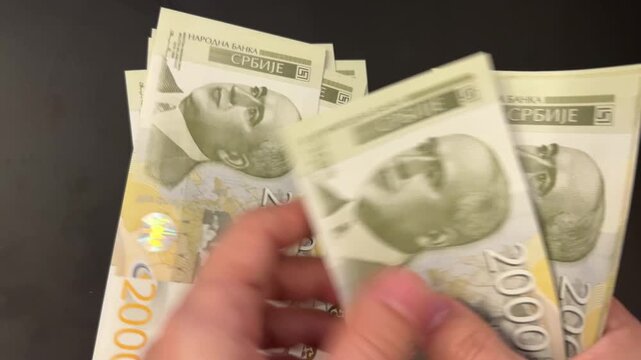 Counting Serbian dinar banknotes. Female hands counting 2000 RSD bills. Family budget, savings and investment concept