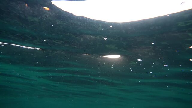 Cinematic Underwater View of Sun Rays Piercing Clear lue Ocean Surface