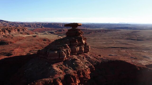 Pull back close to wide shot of Mexican Hat Rock in Utah near sunset.