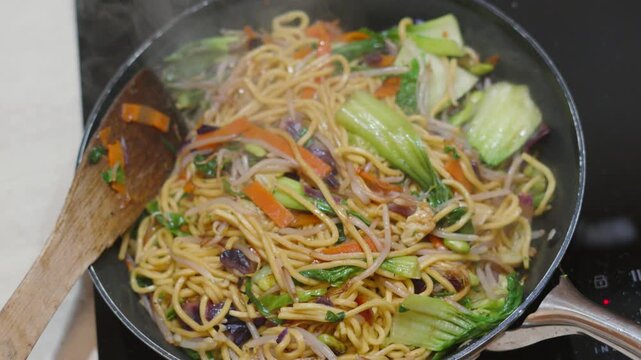 Top View of Freshly Made Hot Stir Fry Noodles with Fresh Vegetables including Bok Choi, Carrots. 4K.
