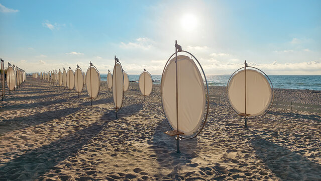 Premium round windbreaks on empty sandy beach landscape