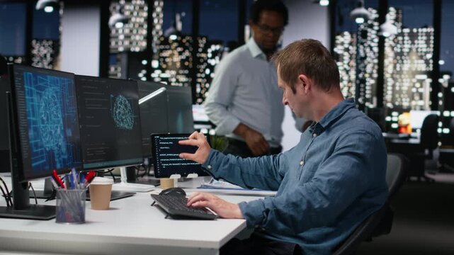 Tech startup IT expert developing artificial intelligence algorithms in high rise office late at night. System administrator debugging neural network brain models on screens for coding workflows.