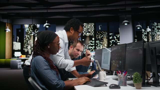 Engineering team brainstorming in office, typing code on computer, developing machine learning models to automate tasks with teamwork and productivity context.
