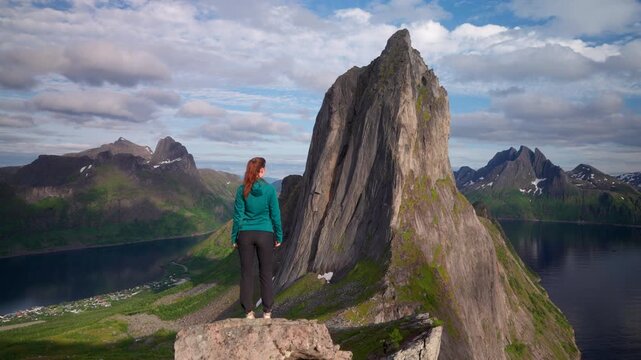View from behind of female adventurer at lookout over impressive Segla mountain