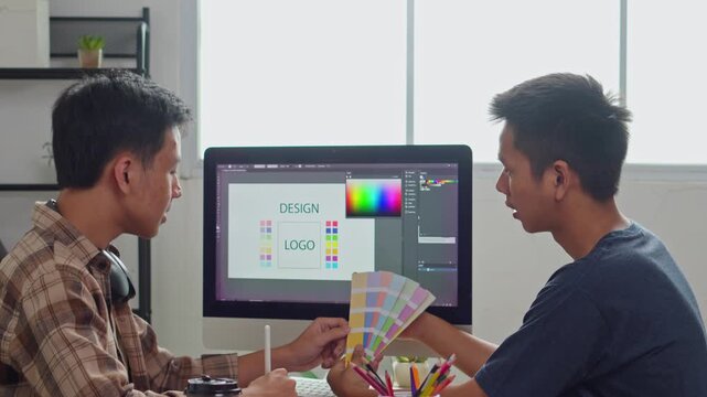 Two creative graphic designers collaborating and choosing the perfect swatches from color palette