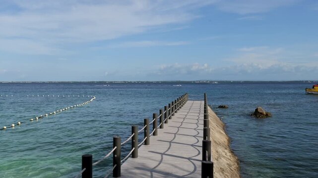 Pier near Vista Mar Beach Resort and Angasil Port, Mactan Island, Lapu Lapu City, Cebu, Philippines, extending across calm tropical waters toward the Olango Channel, static seaside shot.